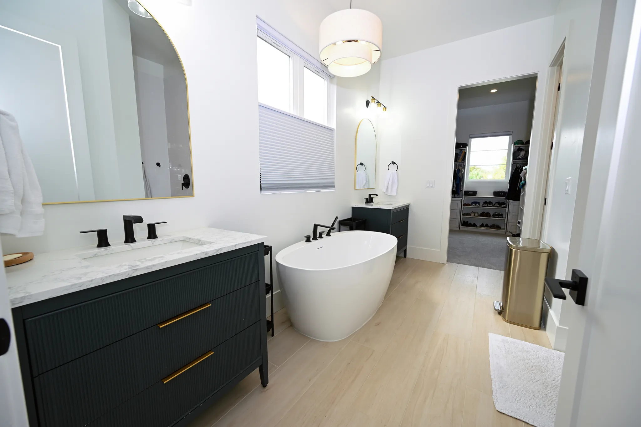 Primary bath with a freestanding tub and a dark vanity