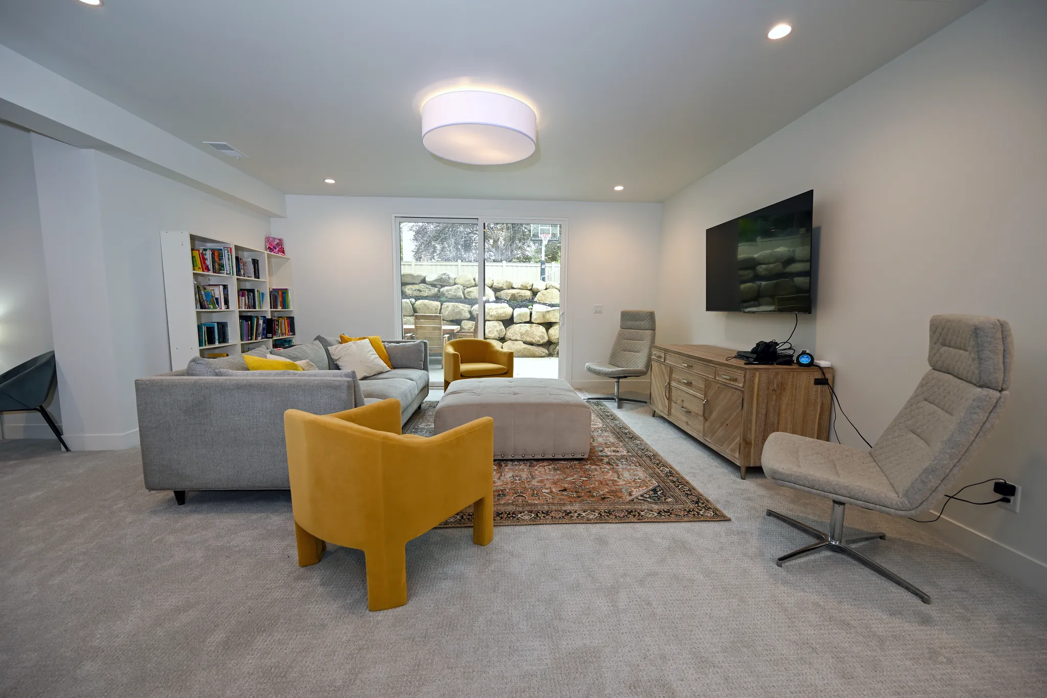 Lower-level family room with a sectional and a window well