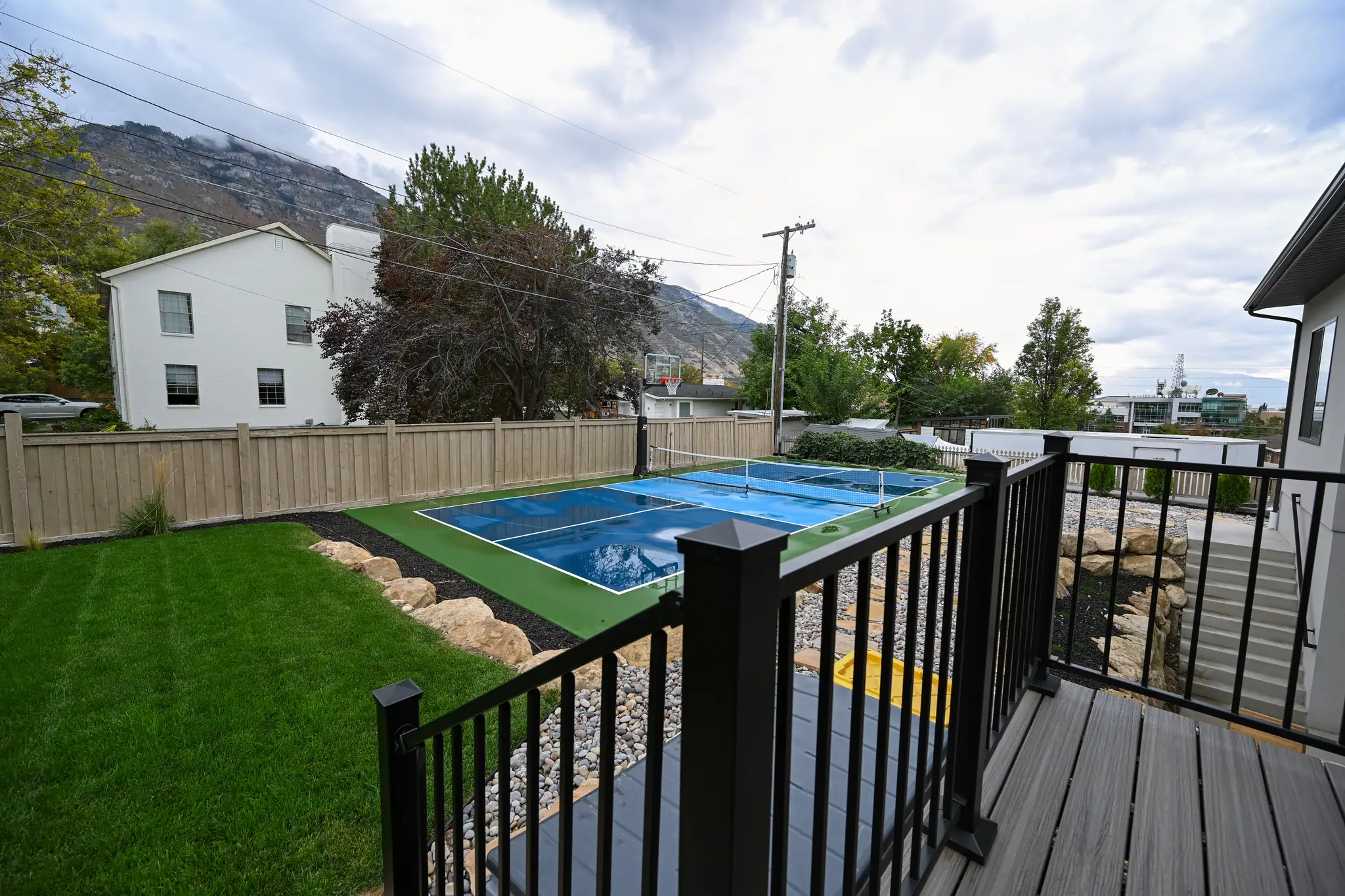 Backyard deck overlooking the lawn and a sport court