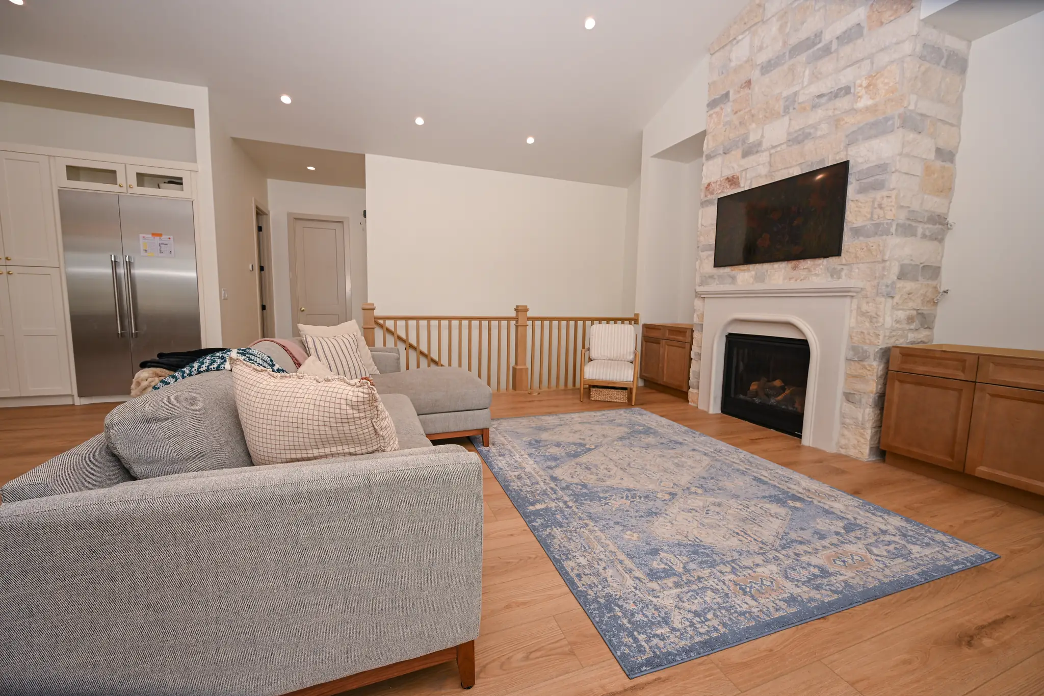 Living room with a stone fireplace that rises to the vaulted ceiling