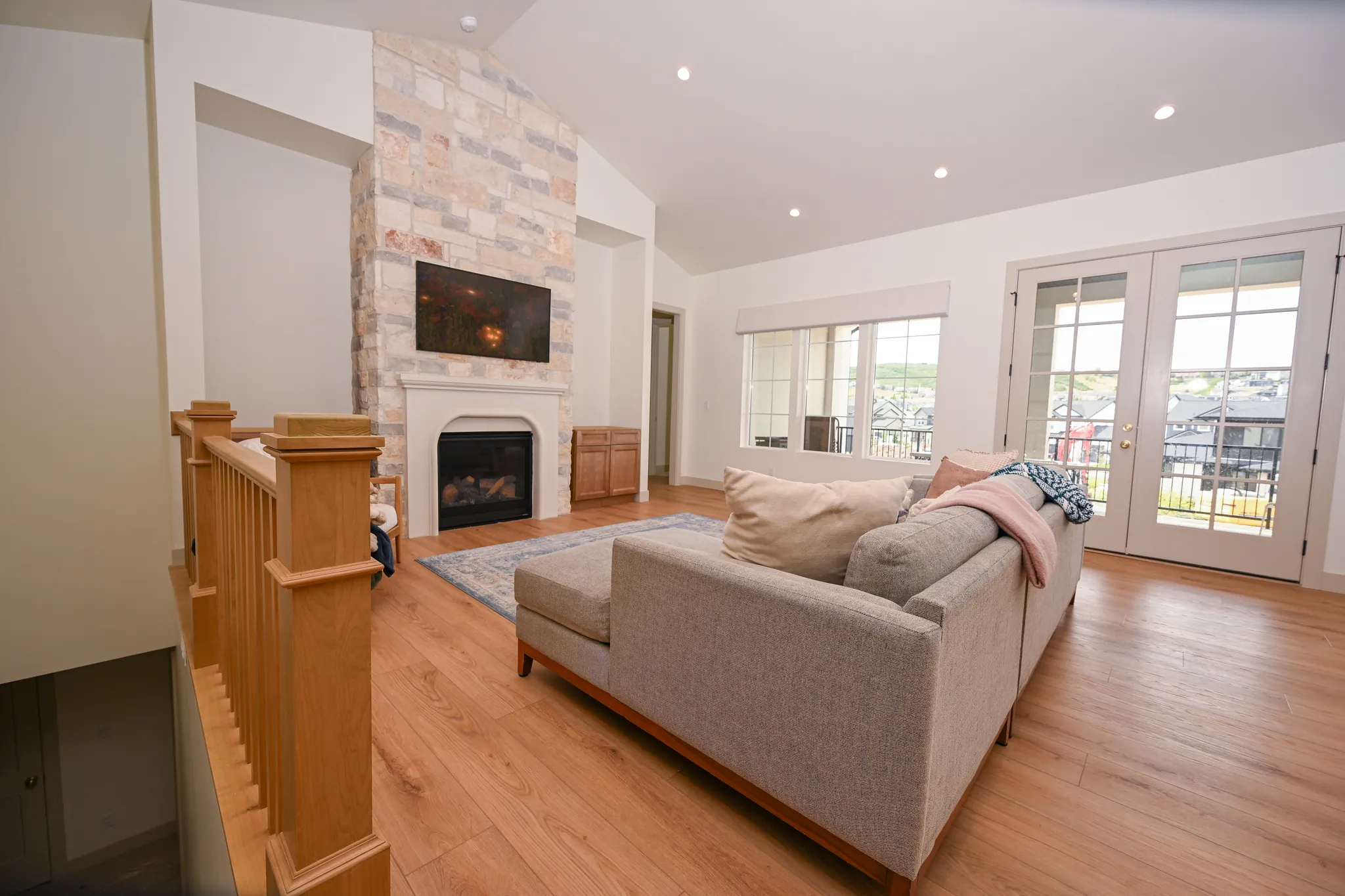 Living room with French doors to the deck and a wood stair railing