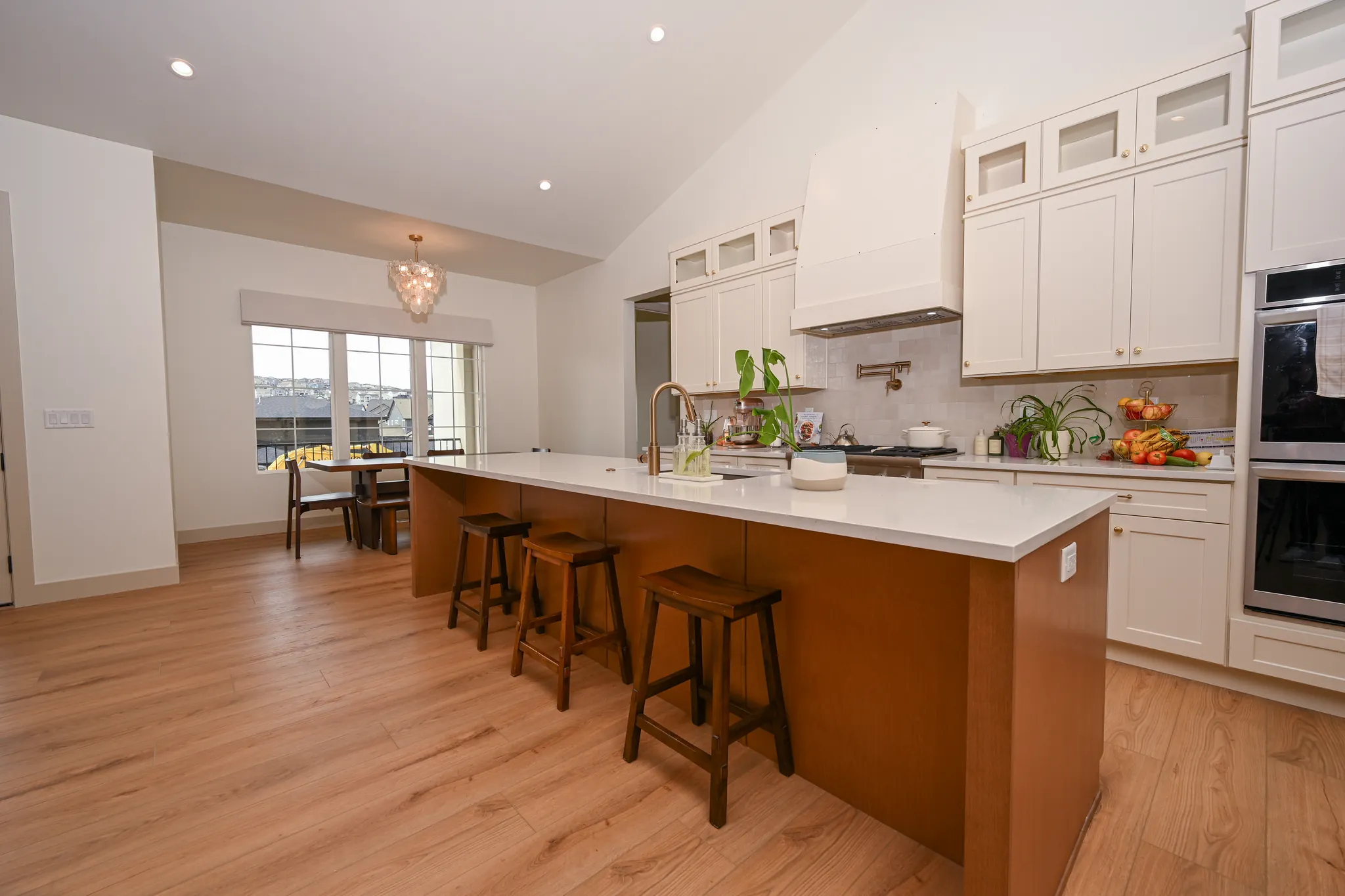 Kitchen with a long wood island, bar stools and cream cabinetry