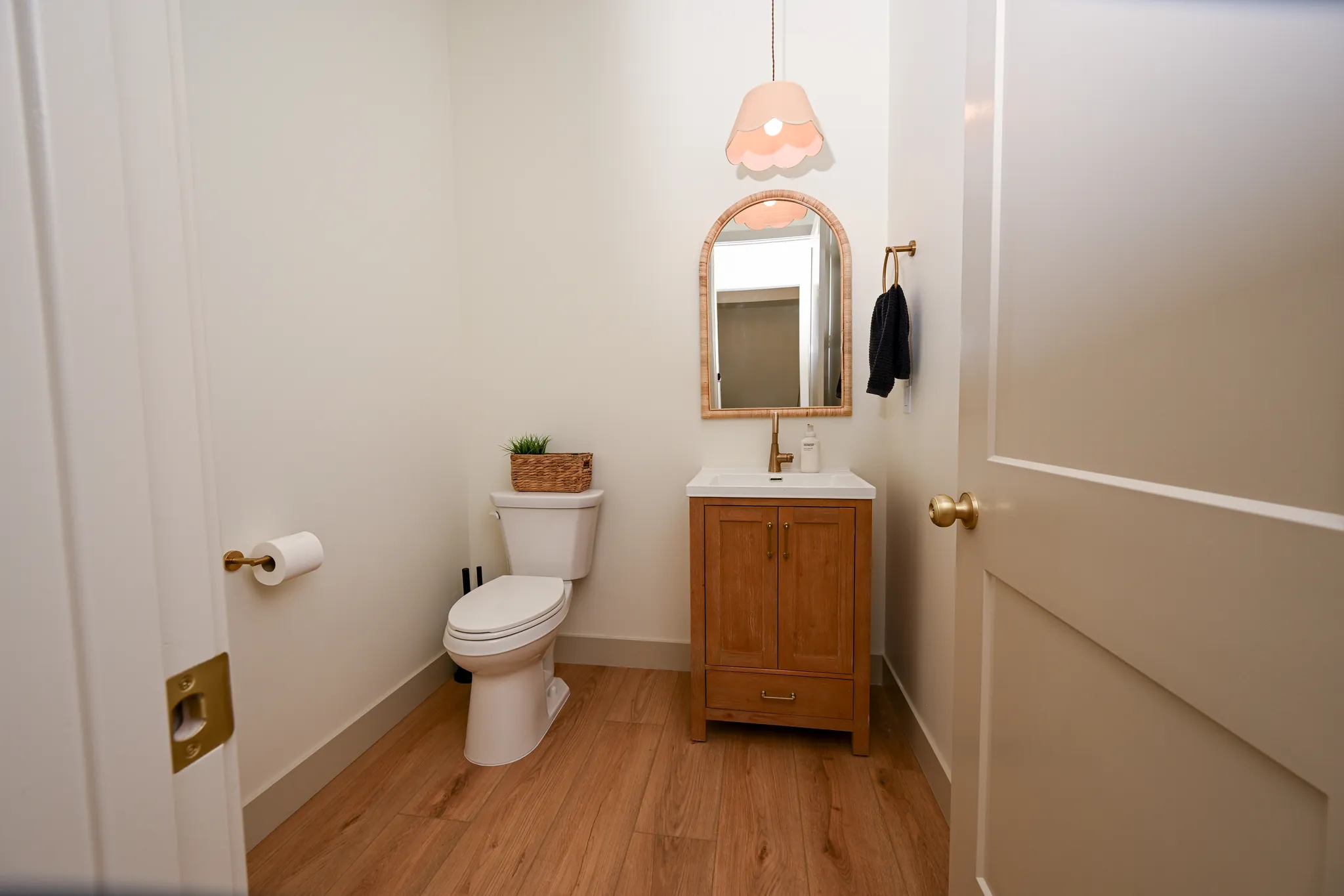 Powder room with a wood vanity and arched mirror