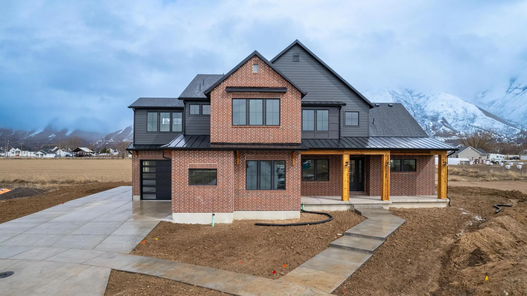Maple Grove Farmstead, a red-brick custom home by Slate Building Company beneath the Wasatch mountains