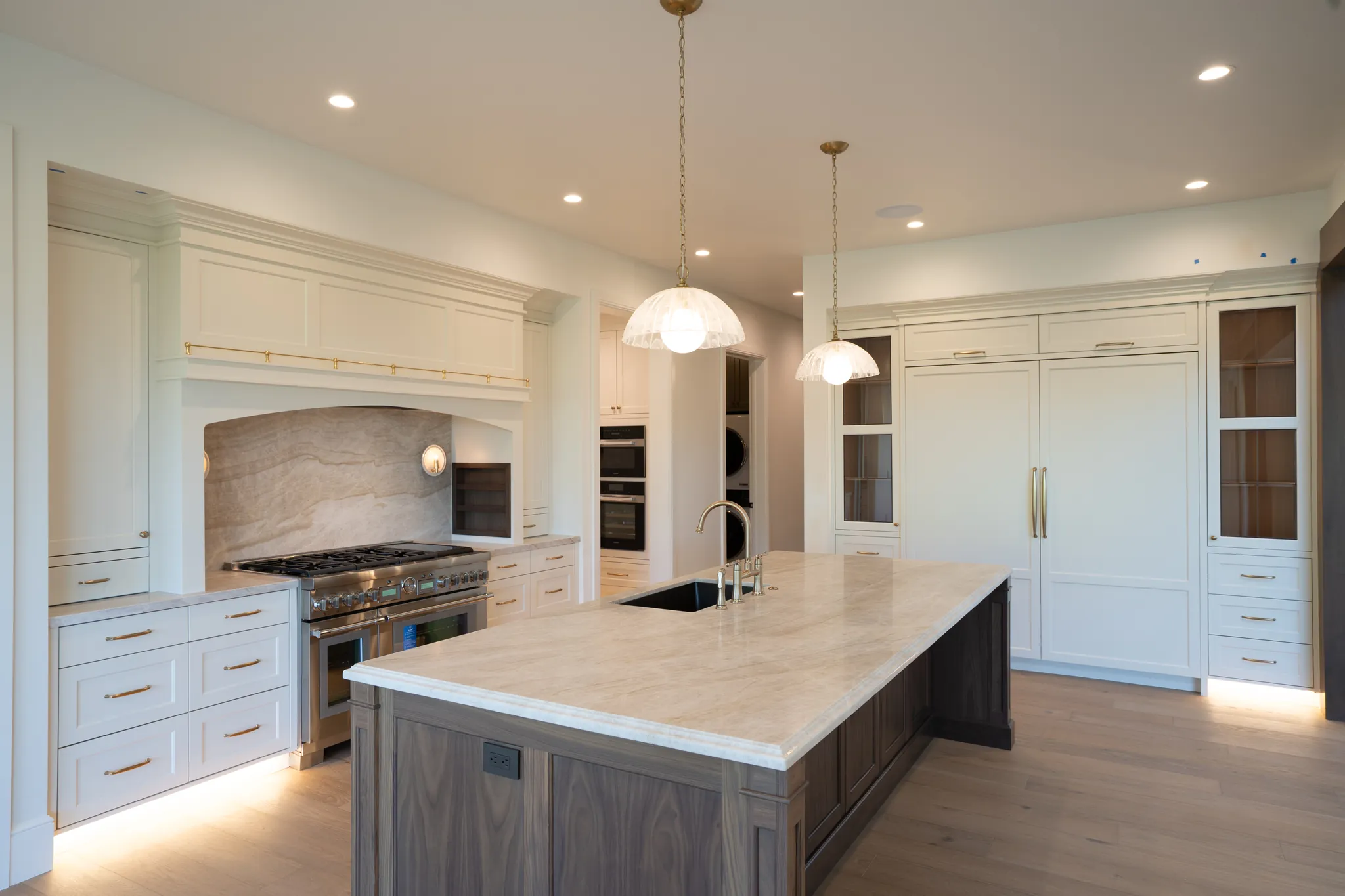 Kitchen island and paneled refrigerator wall