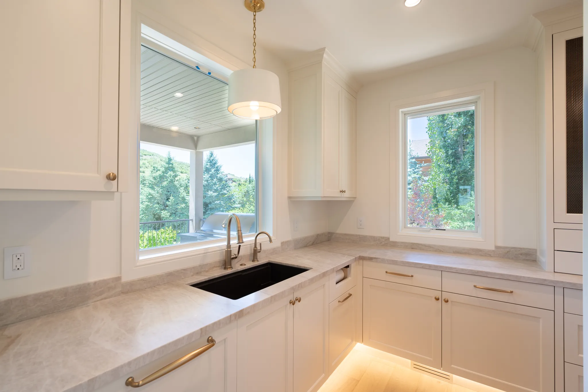 Kitchen sink beneath a window onto the trees, Midway Residence