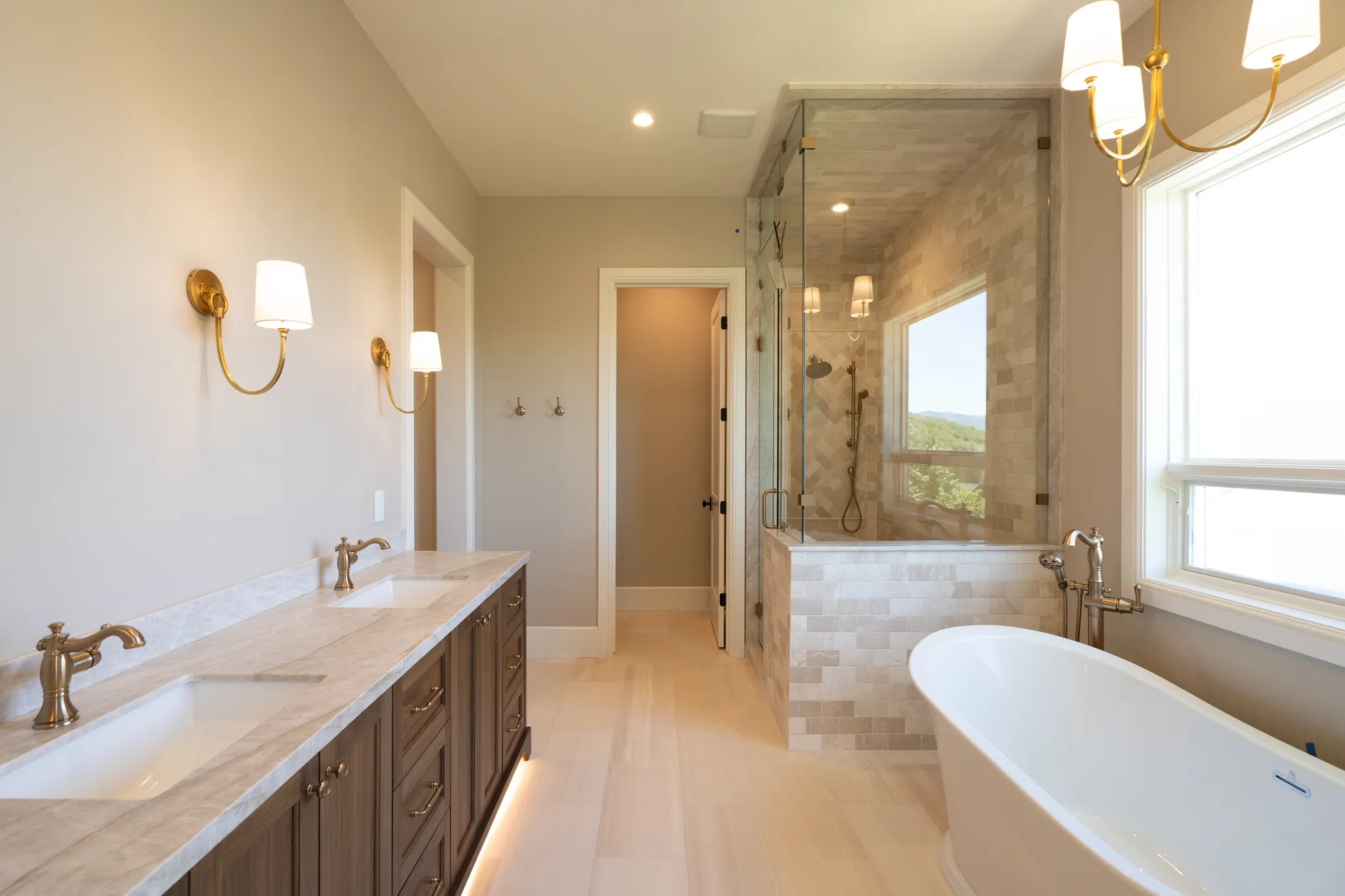 Primary bath with a freestanding tub, double vanity and glass shower