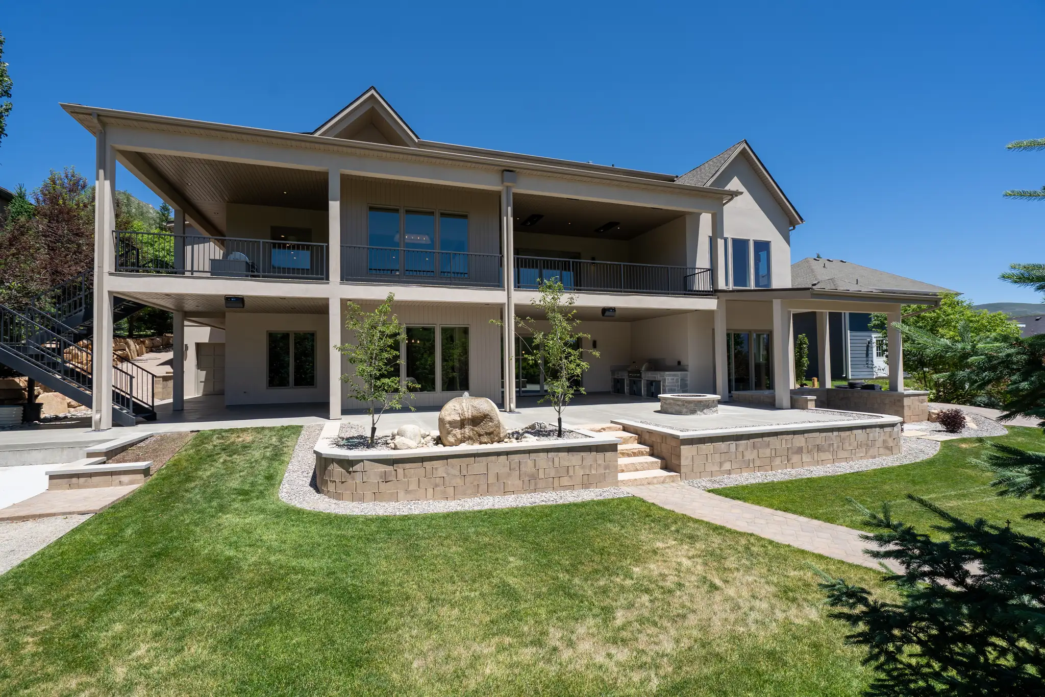 Rear of the Midway Residence with a covered two-level deck and lawn