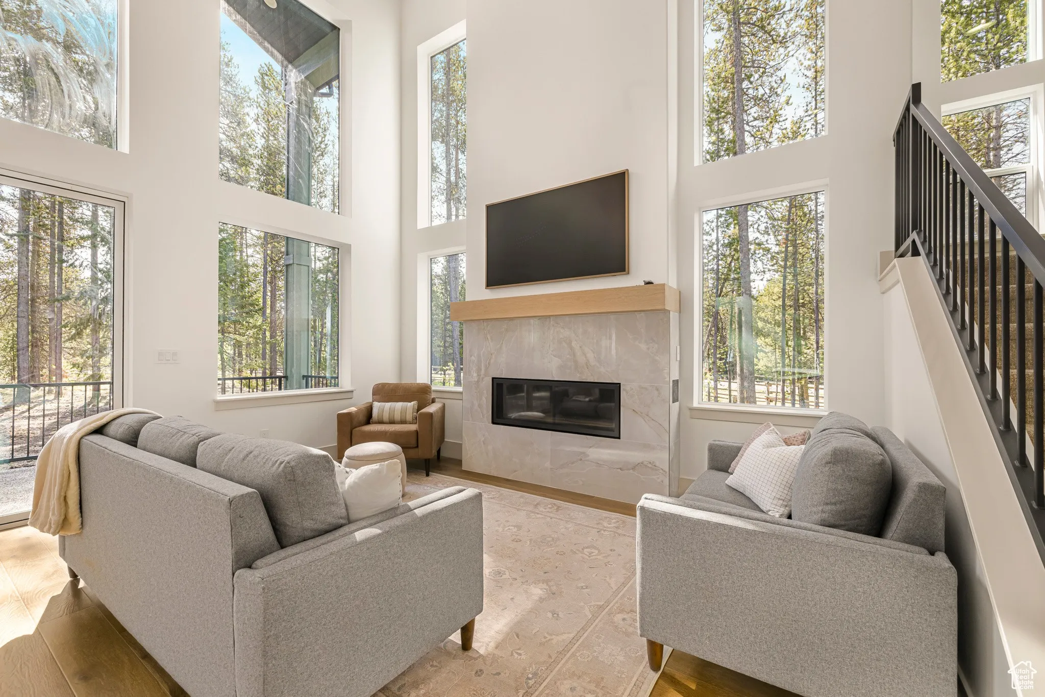 Living room with a tiled fireplace and two-story windows